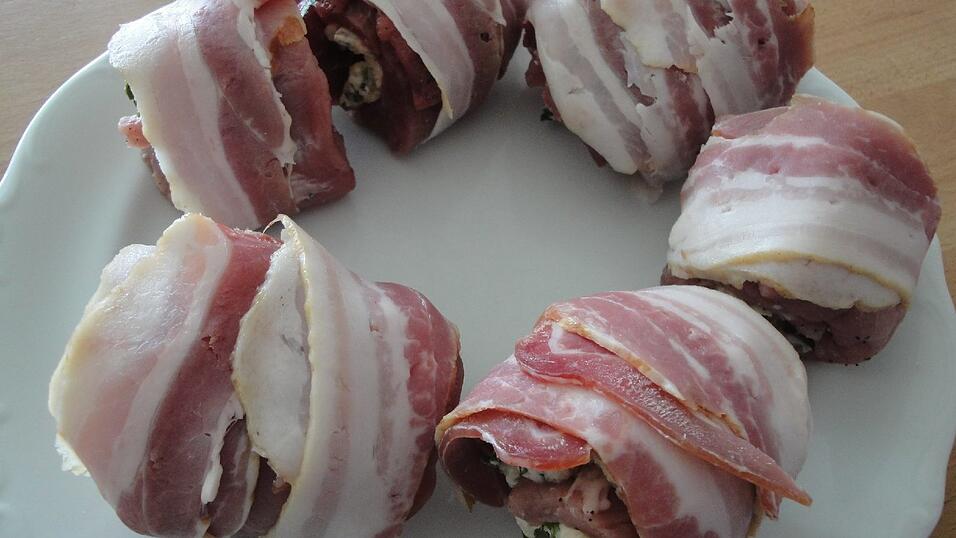 Um jedes Röllchen zwei Streifen Speck wickeln.