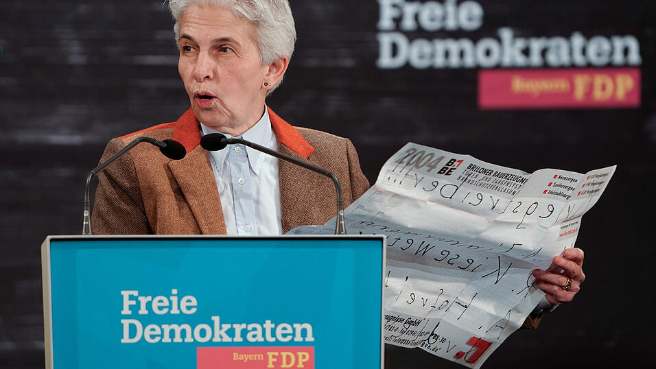 Marie-Agnes Strack-Zimmermann (FDP), Vorsitzende des Verteidigungsausschusses des Deutschen Bundestags, kommentiert während der Aschermittwochsveranstaltung der FDP ein Flugblatt, das Demonstranten im Saal hochgehalten hatten.