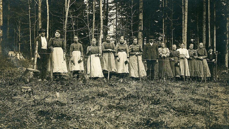 Die Ansichtskarte zeigt eine Gruppe von Frauen im Wald vor einer gespannten Schnur. Es handelt sich um&nbsp; Baumpflanzerinnen oder Kulturfrauen. Das Aufforsten war insbesondere durch die Abholzungen w&auml;hrend der Kriege dringend n&ouml;tig. Das Foto wurde vom Fotografen Ludwig Hirsch aus Waldkirchen (Landkreis Freyung-Grafenau) aufgenommen.
