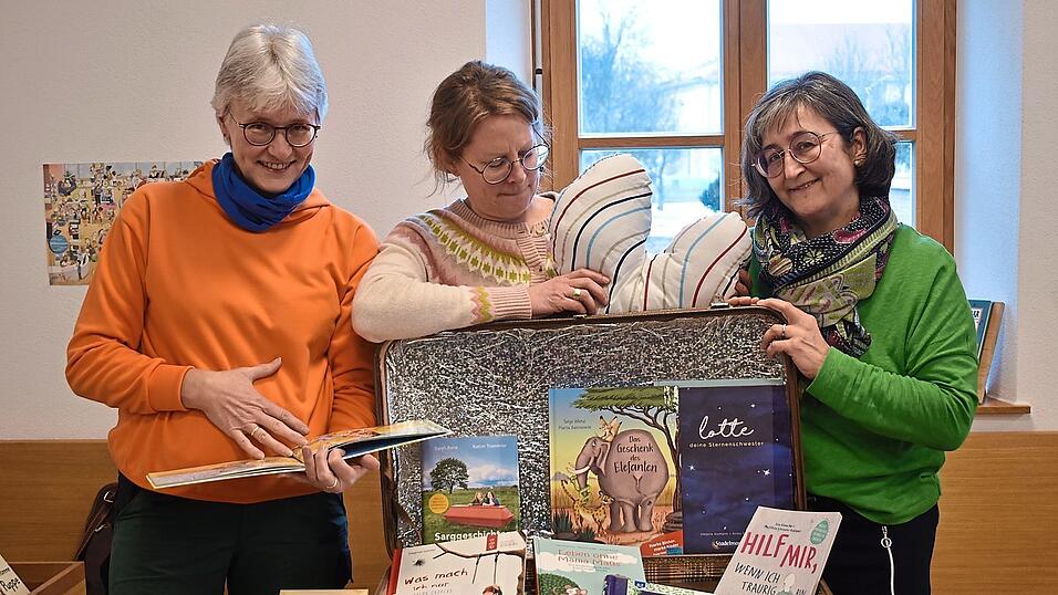 So sieht der &bdquo;Trostkoffer&ldquo; aus. Dahinter in der Mitte Monika Obermeier vom B&uuml;chereiteam mit den Geldgebern Irmi Diewald (links) und Anja Feichtinger (rechts).