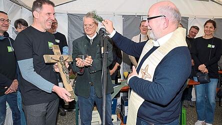 Pfarrer Gerhard Wiesheu (r.) segnete im Beisein von Pastor Steven Dunn (M.) und Vorsitzendem Torsten Koch (l.) das Kreuz.