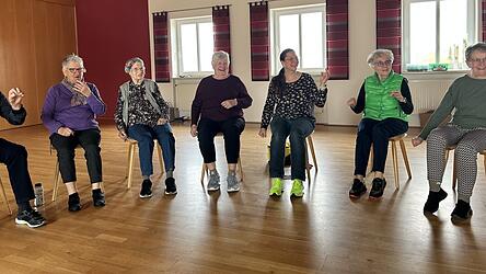 Demenzverz&ouml;gerin Sabine Schwarzfischer inmitten ihrer Kursteilnehmer. Gerade &uuml;ben die Senioren die Koordination von H&auml;nden und F&uuml;&szlig;en. Bewegung ist ein wichtiger Teil der Demenzverz&ouml;gerungskurse.