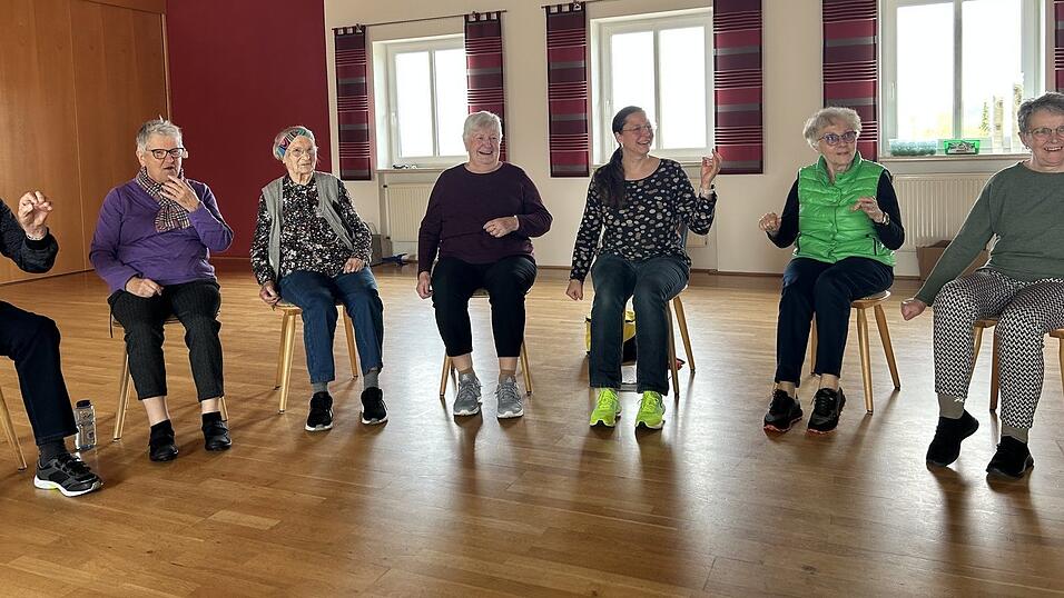Demenzverz&ouml;gerin Sabine Schwarzfischer inmitten ihrer Kursteilnehmer. Gerade &uuml;ben die Senioren die Koordination von H&auml;nden und F&uuml;&szlig;en. Bewegung ist ein wichtiger Teil der Demenzverz&ouml;gerungskurse.
