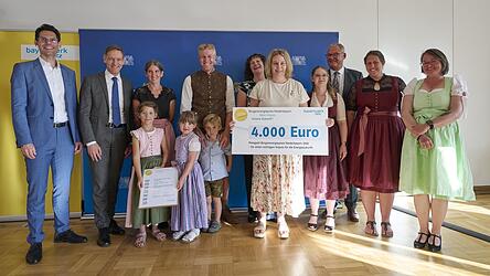 Bei der Scheck&uuml;bergabe am Mittwochabend: Markus Leczycki, Leiter Kommunalmanagement Bayernwerk Netz GmbH (v.l.), Regierungspr&auml;sident Rainer Haselbeck, Ramona St&ouml;mmer, Kita Simbach, der Simbacher B&uuml;rgermeister Anton Sporrer, Tanja Karl, Vorsitzende Pfarrcaritas, Einrichtungsleitung Verena Wei&szlig;, Anna Kulla (Kita), stellvertretender Landrat Josef Pellkofer, Lisa Pichlmaier und Izabela Piernicki (beide Kita) sowie vorne die Kitakinder Hannah, Theresa und Lorenz.