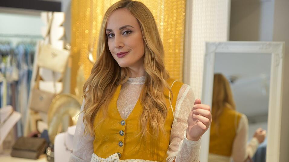 Das senfgelbe Dirndl trägt man beispielsweise in Kombi mit einer langärmeligen Spitzenbluse. Das Outfit in Lederhose & Co. ist farblich abgestimmt.