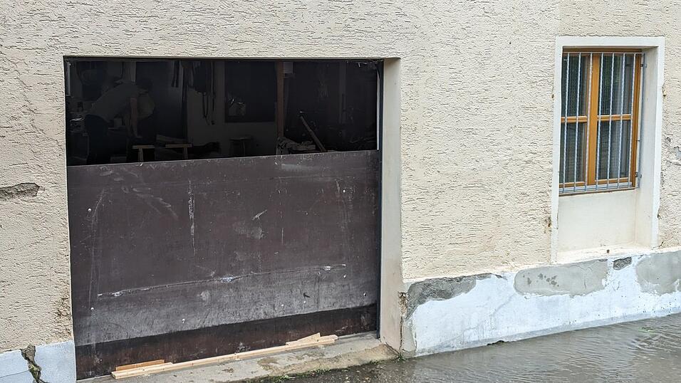 Flussnahe Anwohner versuchen, Türen und Garagen mit Holzverhauen abzudichten. Flussnahe Anwohner versuchen, Türen und Garagen mit Holzverhauen abzudichten.