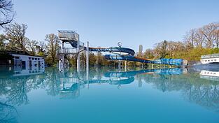 Eine Wasserrutsche spiegelt sich in einem Becken im Stadionbad.