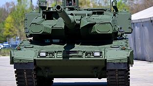 Ein Kampfpanzer Leopard 2 steht auf dem Werksgel&auml;nde des Unternehmens KNDS vor einer Werkshalle. Ausgaben f&uuml;r milit&auml;rische Ger&auml;te sind auf einem Rekordhoch.