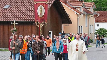 Die Fu&szlig;wallfahrer aus Steinbach im Landkreis Dingolfing-Landau ziehen in Begleitung des Kreuzes und der Haindlinger Marienfahne mit Pfarrer Markus Schwarzer unter vollem Gel&auml;ute der Wallfahrtskirche Haindling in den Gnadenort mit der Mutter Gottes ein.