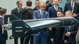 Diese Drohne von Auterion und Airlogix hat eine Reichweite von bis zu 1500 Kilometern. Im April führte sie Auterion-Chef Lorenz Meier (ganz inks, seitlich von hinten zu sehen) Bundeskanzler Friedrich Merz (CDU) und dem ukrainischen Präsident Wolodymyr Selenskyj vor. Diese Drohne von Auterion und Airlogix hat eine Reichweite von bis zu 1500 Kilometern. Im April führte sie Auterion-Chef Lorenz Meier (ganz inks, seitlich von hinten zu sehen) Bundeskanzler Friedrich Merz (CDU) und dem ukrainischen Präsident Wolodymyr Selenskyj vor.
