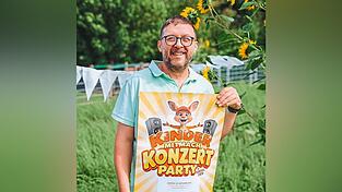 B&uuml;ndnis-Vorsitzender Martin Rank zeigt das Donikklplakat und die wei&szlig;en Wimpel.