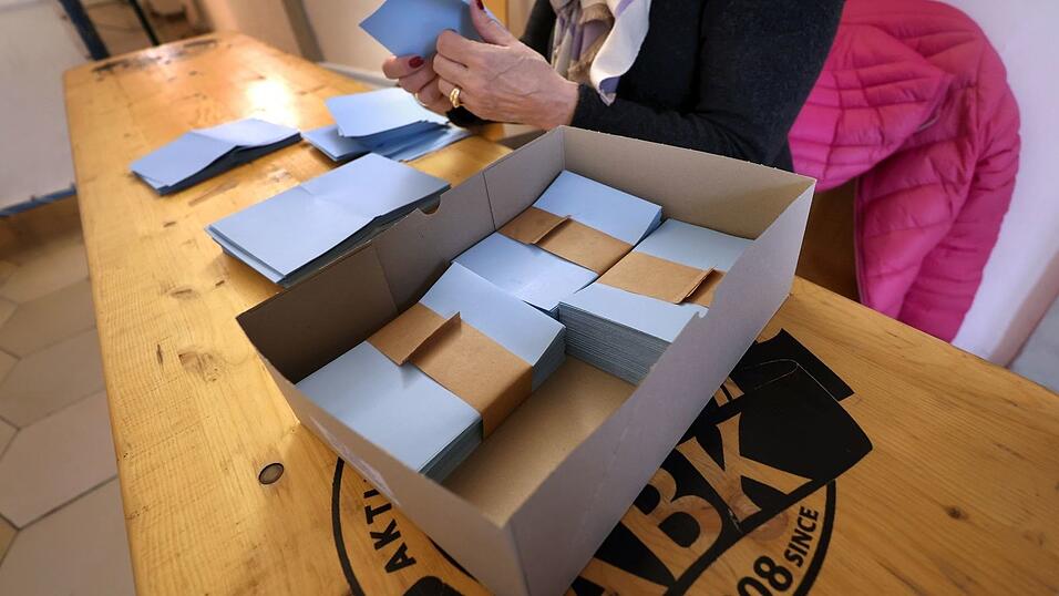 Eine Wahlhelferin sortiert bei der Stichwahl Stimmzettel.