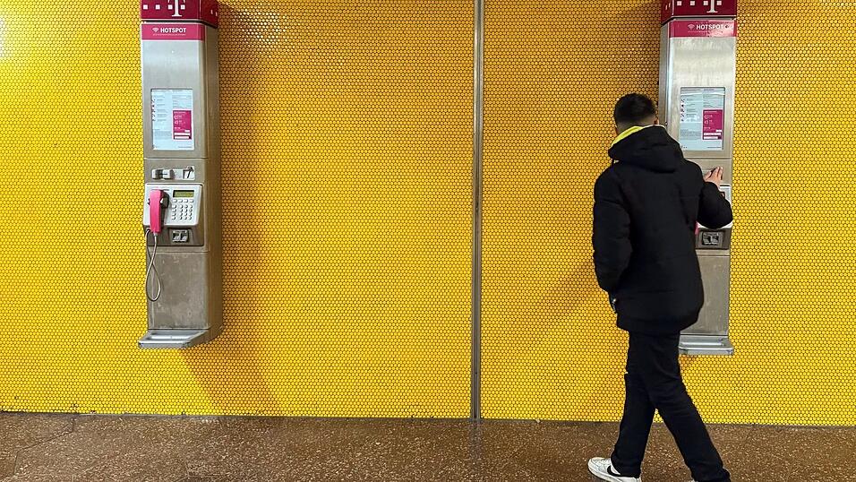 Zwei Wandtelefone am Bochumer Hauptbahnhof - mancher Passant bleibt stehen und blickt verwundert auf die alte Technik.