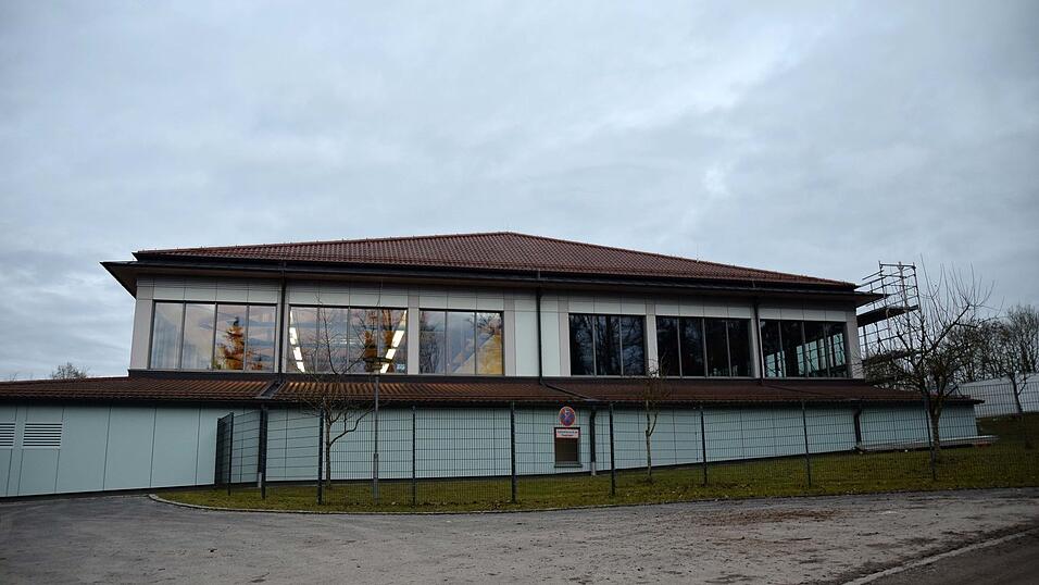 Kronwinkler Doppelturnhallen-R&uuml;ckansicht: Der linke Teil (beleuchtet) ist in Betrieb, der rechte Teil (dunkel) ist gesperrt.