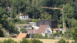 Blick von einem H&uuml;gel auf das Areal in Schweinbach, f&uuml;r das ein einfacher Bebauungsplan gilt. Sein Geb&auml;ude, sagt der Bauherr eines schwarzen Neubaus, f&uuml;ge sich &bdquo;r&uuml;cksichtsvoll in die Umgebung ein&ldquo;. Nachbarn sehen das anders.