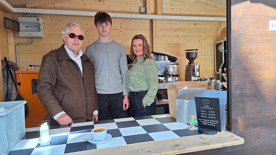 Das Team des Kaffekiosks steht nun in einer Kaffeebude.