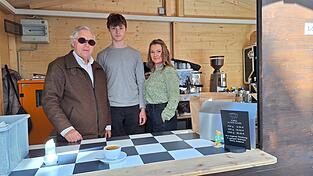 Das Team des Kaffekiosks steht nun in einer Kaffeebude.
