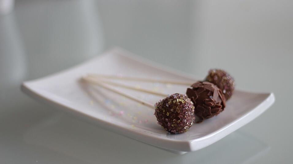 Die Kuvertüre trocknet relativ schnell auf den gefrorenen Kugeln. Die Kuvertüre trocknet relativ schnell auf den gefrorenen Kugeln.