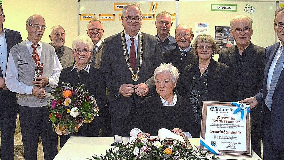 Roswitha Reichersammer (sitzend), Annemie Zeiller (4.v.l.) und der M&auml;nnerchor wurden beim Neujahrsempfang f&uuml;r ihre herausragenden ehrenamtlichen Leistungen geehrt.