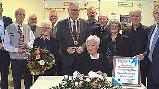 Roswitha Reichersammer (sitzend), Annemie Zeiller (4.v.l.) und der M&auml;nnerchor wurden beim Neujahrsempfang f&uuml;r ihre herausragenden ehrenamtlichen Leistungen geehrt.