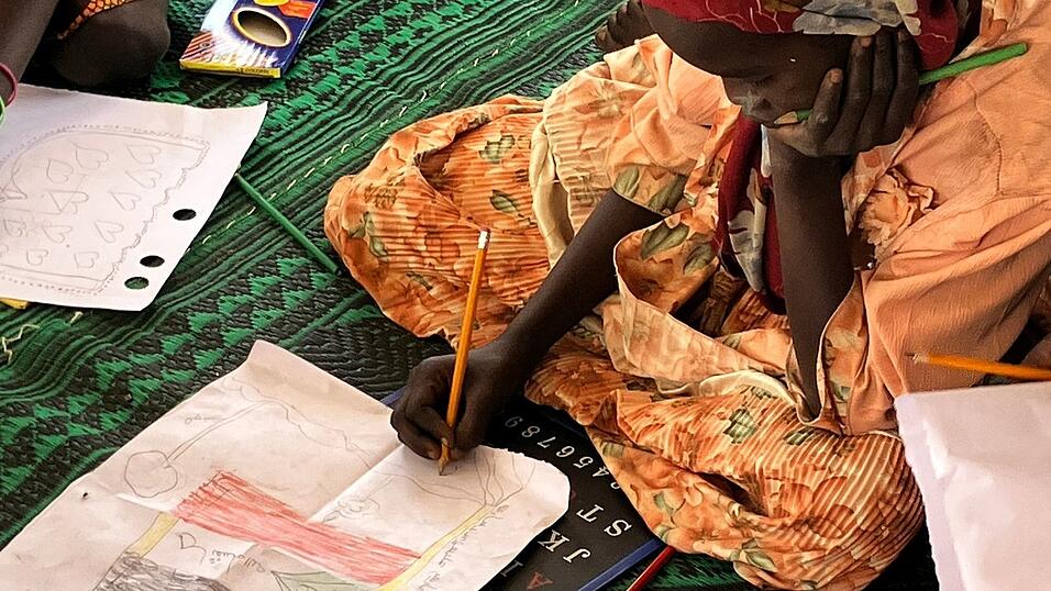 Ein kleines Mädchen malt die sudanesische Flagge. Ein kleines Mädchen malt die sudanesische Flagge.