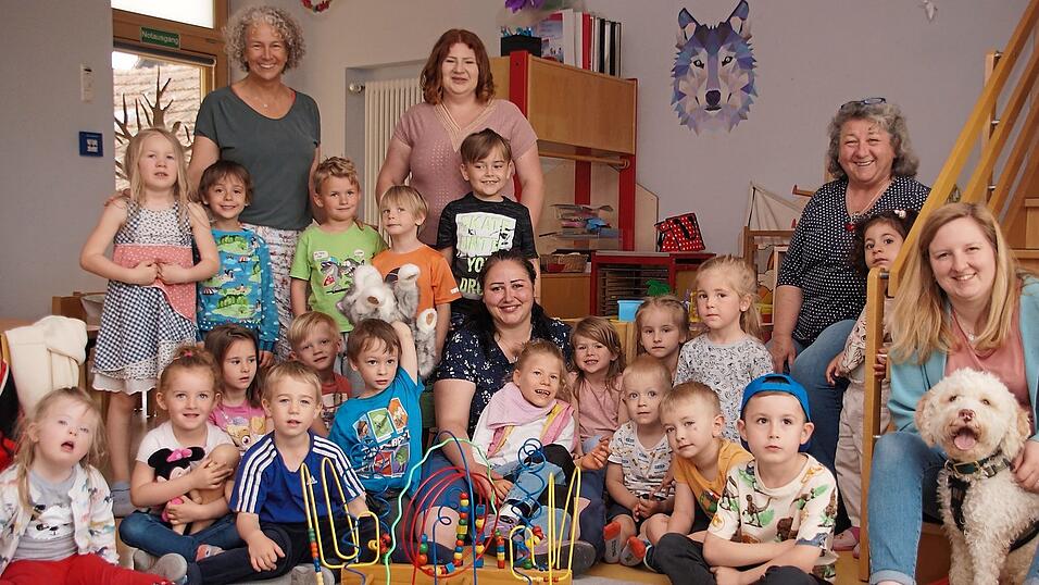 Theresa Jakomet lacht und f&uuml;hlt sich pudelwohl bei ihrer Individualbegleitung Babette Philipp und inmitten ihrer Kindergartenfreunde mit Kita-Leiterin Christina Dommer (rechts), Kindergartenhund Cosmo sowie die Erzieherinnen Christa Lutz, Nicole und Christine Leyerer (von rechts nach links).