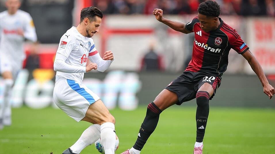 Kiel-Kapitän Steven Skrzybski (links) und Pape Demba Diop von Nürnberg kämpfen um den Ball. Kiel-Kapitän Steven Skrzybski (links) und Pape Demba Diop von Nürnberg kämpfen um den Ball.
