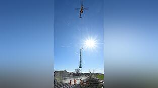 Der Blick auf das Stellen von neuen Oberleitungsmasten mittels Helikopter. Der Blick auf das Stellen von neuen Oberleitungsmasten mittels Helikopter.