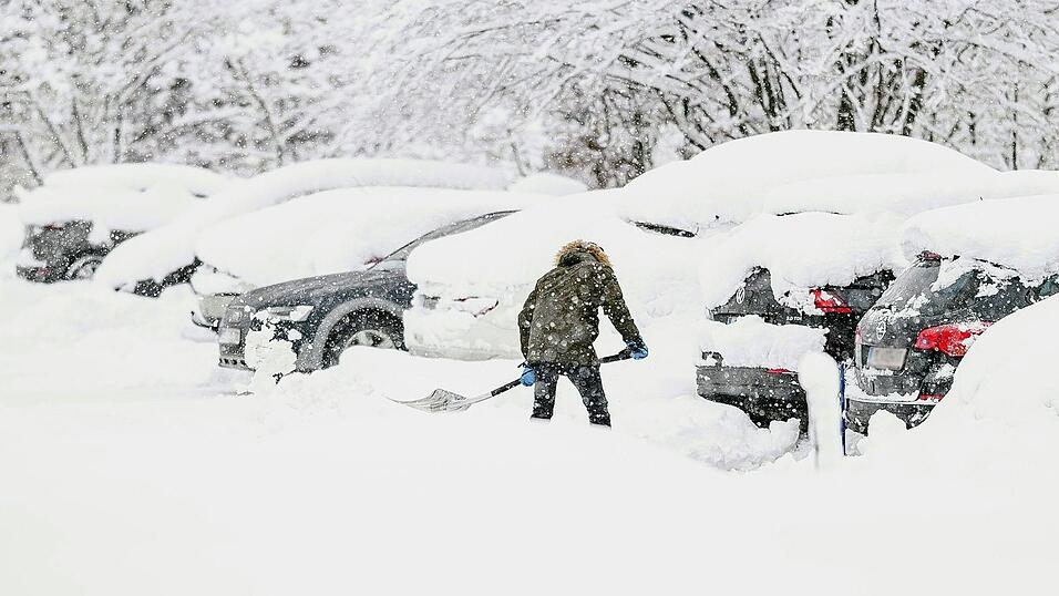 Ein Mann schaufelt am Mittwoch sein Auto auf einem Parkplatz in Saalbach aus. Ein Mann schaufelt am Mittwoch sein Auto auf einem Parkplatz in Saalbach aus.