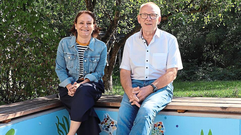 Vize-Rektorin Christine Kettner und Schulleiter Martin Voggenreiter sitzen auf den Betonb&auml;nken im Schulhof. Sch&uuml;ler haben sie mit Meeresmotiven blau gestrichen und die Sitzfl&auml;che mit Holz begleitet. Eine Aufgabe im neuen Schuljahr: die Beschattung.