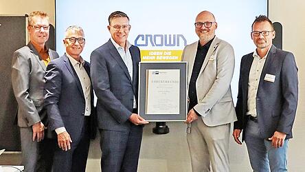 Ken Dufford, Crowns Vice President Europe (Dritter von rechts), und Werksleiter Mario Kulzer (Zweiter von links) nehmen die Urkunde der IHK entgegen.