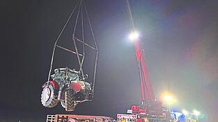 Mit einem Schwerlastkran wurde der Traktor auf einen Tieflader gehoben.