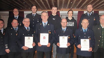 Kreisbrandinspektor Karl Hahn (links) und Zweiter B&uuml;rgermeister Valentin Petermeier (rechts) mit den geehrten Mitgliedern, der Vorstandschaft und Neumitgliedern der Feuerwehr Reichlkofen.