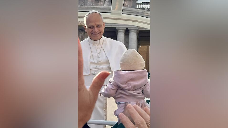 Direkt vor der Reisegruppe hält das Papamobil und Papst Leo XIV. segnet ein Kind. Direkt vor der Reisegruppe hält das Papamobil und Papst Leo XIV. segnet ein Kind.