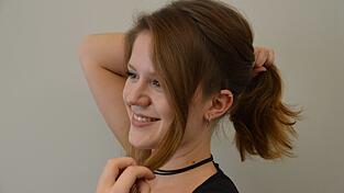 Teile mit einem Kamm die Stirnpartie auf beiden Seiten ab und ziehe einen Scheitel von Ohr zu Ohr.