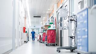 Eine Pflegekraft geht auf einer Intensivstation über den Flur. Eine Pflegekraft geht auf einer Intensivstation über den Flur.