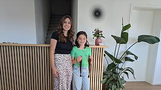 Friseurin Magdalena Müller mit Valentina Rrahmani, die ihre Zöpfe in der Hand hält. Rund 30 Zentimeter kürzer sind die Haare der Achtjährigen nun. Die kurzen Haare passen viel besser zu ihrem lebhaften Charakter, wie auch ihre Mutter Irena findet.