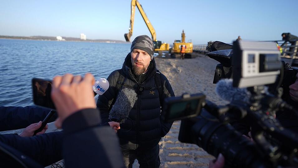 Robert Marc Lehmann spricht mit den Medien am Strand, in dessen N&auml;he der gestrandete Buckelwal im Wasser gelegen hatte.