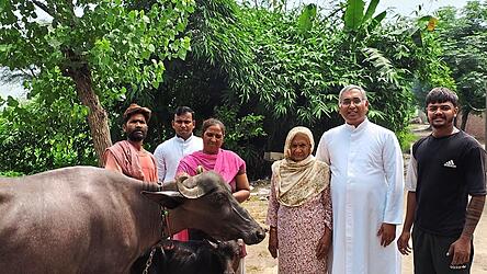 Pater John Joseph (Zweiter von rechts) bei der &Uuml;bergabe einer Kuh. Deren Milch hilft, die Armut zu lindern.