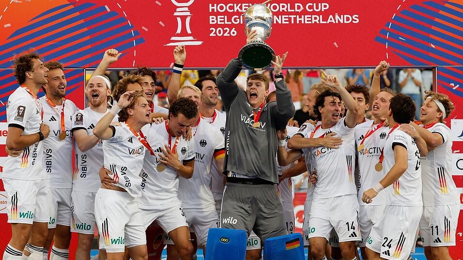 Die deutschen Hockeyspieler mit dem WM-Pokal. Die deutschen Hockeyspieler mit dem WM-Pokal.