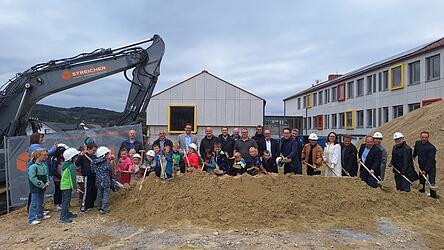 Oberbürgermeister Dr. Christian Moser, Stadträte, Architekt, Vertreter des Bauamtes, Lehrer und Kinder freuen sich auf die neue Turnhalle.