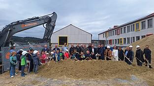 Oberbürgermeister Dr. Christian Moser, Stadträte, Architekt, Vertreter des Bauamtes, Lehrer und Kinder freuen sich auf die neue Turnhalle.