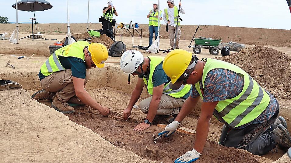 Mit Schabern, Spateln und bloßen Händen räumen die Archäologen die Erde von den Skelettteilen. Mitten im Lössboden befindet sich ein Grab aus der Jungsteinzeit. Auch die Keramikkanne als Grabbeigabe ist noch gut erhalten. 20 solcher Gräber wurden bei Vorarbeiten für den Südostlink bei Sengkofen entdeckt.
