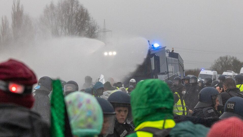Die Polizei setzt Wasserwerfer gegen Demonstranten ein, die die B429 nahe der Lahnbr&uuml;cke blockieren.