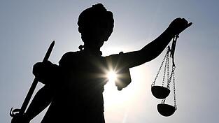 Statue der Justitia mit einer Waage und einem Schwert in der Hand.