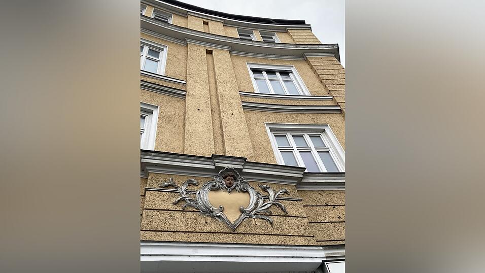 Die Fassade mit ihren schm&uuml;ckenden Emblemen ist ein markanter Blickpunkt an der Ecke Kennedyplatz.