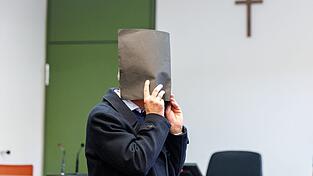 Der Angeklagte versteckte zu Prozessbeginn sein Gesicht. Er bestreitet die Vorwürfe. (Archivfoto)