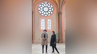 Markus Lüpertz und Maria Baumann vor den Glasfenstern mit jetzt noch Klarglas, die bunt werden sollen. Davor wird der Künstler die Kirche mit einer Ausstellung bereichern.