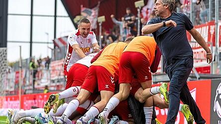 Große Erleichterung beim SSV Jahn Regensburg: Nach dem 2:0 durch Phil Beckhoff in der Nachspielzeit schaut auch Trainer Michael Wimmer bei der Jubeltraube vorbei.