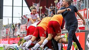 Große Erleichterung beim SSV Jahn Regensburg: Nach dem 2:0 durch Phil Beckhoff in der Nachspielzeit schaut auch Trainer Michael Wimmer bei der Jubeltraube vorbei.